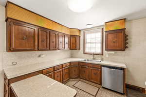 Kitchen featuring tasteful backsplash, sink, and dishwasher