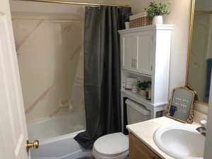 Full bathroom with vanity, shower / bath combination with curtain, and toilet