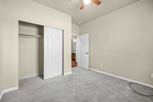 Unfurnished bedroom with light carpet, a closet, a ceiling fan, and baseboards