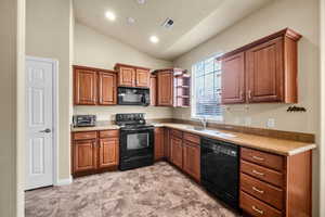 Kitchen featuring visible vents, light countertops, black appliances, open shelves, and a sink