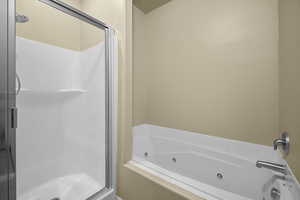 Full bathroom with a shower stall and a whirlpool tub