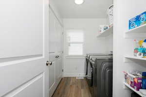 Laundry room with washing machine and dryer and hardwood / wood-style floors