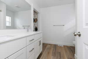 Primary Bathroom with vanity, toilet, and hardwood / wood-style floors