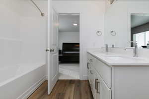 Primary Bathroom featuring shower / bath combination, vanity, and hardwood / wood-style floors