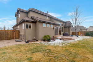 Back of house featuring a fenced yard, walk out deck, large concrete patio with gas BBQ and stucco siding