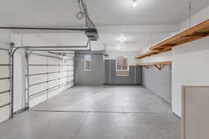 Custom 3 car Garage with a garage door openers, epoxy flooring, custom cabinetry, custom wall mounting system & over head shelving.