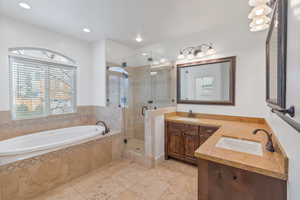 Primary Full bathroom featuring a stall shower, a garden tub, double sinks, and tile patterned floors