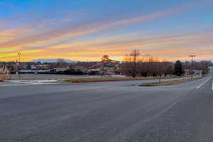 View of road featuring street lighting, curbs, sidewalks, and a mountain view