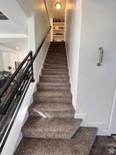 Stairway with wood finished floors and baseboards