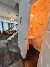 Bathroom featuring wallpapered walls, baseboards, and wood finished floors