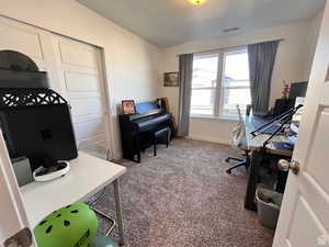 Carpeted office with baseboards and visible vents