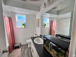 Bathroom featuring a wealth of natural light, shower / bath combo, visible vents, and wood finished floors