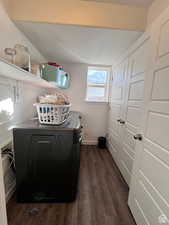 Laundry area with laundry area, baseboards, dark wood finished floors, and washing machine and clothes dryer