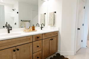 Bathroom with a sink, baseboards, and double vanity