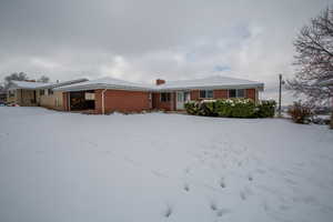 View of front of house with a garage, brick siding, and a chimney