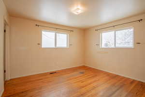 Spare room with baseboards, visible vents, plenty of natural light, and light wood finished floors