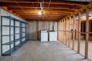 Unfinished basement featuring washing machine and clothes dryer