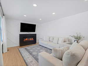 Living area featuring recessed lighting, wood finished floors, and a fireplace