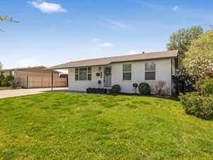 Ranch-style home with brick siding, fence, a front yard, and concrete driveway