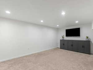 Unfurnished living room with recessed lighting, baseboards, and carpet floors