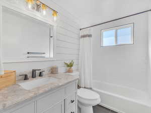 Full bath featuring shower / tub combo, vanity, and toilet