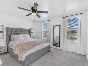 Bedroom with baseboards, ceiling fan, and light colored carpet