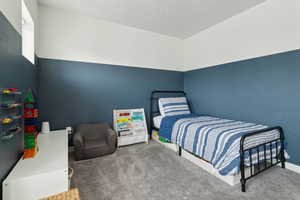 Bedroom featuring carpet and a textured ceiling