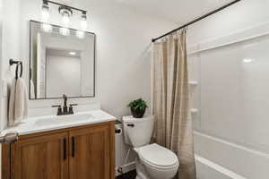 Full bath with toilet, visible vents, vanity, and shower / tub combo with curtain