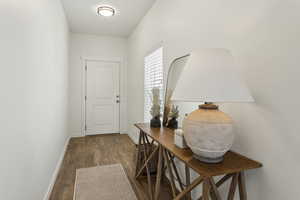 Doorway with baseboards and wood finished floors