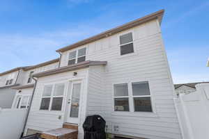 Rear view of house with board and batten siding and fence