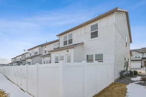 Rear view of house with central AC unit, fence, and board and batten siding