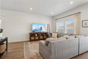 Living room with recessed lighting, dark wood finished floors, and baseboards