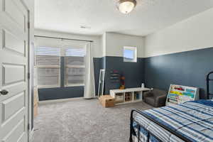 Carpeted bedroom with a textured ceiling and visible vents