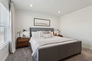 Bedroom with recessed lighting, dark carpet, and baseboards