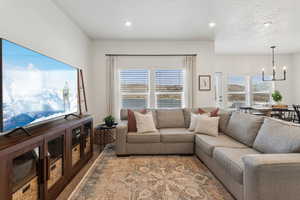 Living room with a chandelier, a textured ceiling, a wealth of natural light, and recessed lighting