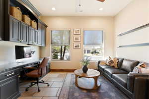 Office space featuring stone tile floors, baseboards, built in desk, and recessed lighting