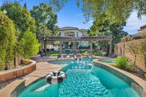 View of swimming pool with a patio, a fenced backyard, an in ground hot tub, a fenced in pool, and a pergola