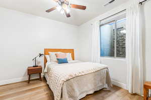 Bedroom featuring ceiling fan, light wood-type flooring, visible vents, and baseboards