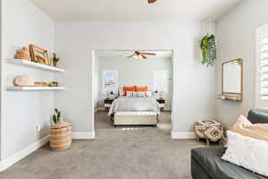 Carpeted bedroom featuring a ceiling fan and baseboards