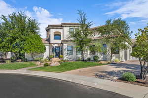 Mediterranean / spanish home with decorative driveway, a front yard, a tile roof, and stucco siding