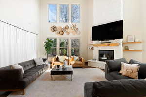 Living room with a stone fireplace and a towering ceiling