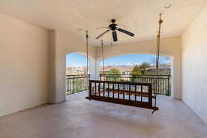 View of patio with a ceiling fan, a mountain view, and a balcony