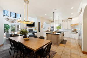 Dining area featuring a healthy amount of sunlight, recessed lighting, arched walkways, and a glass covered fireplace