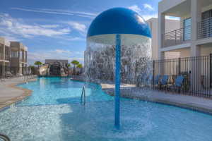 Community pool featuring a water slide and fence