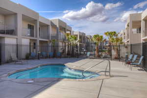 View of swimming pool featuring a swimming pool, a patio area, fence, and a residential view