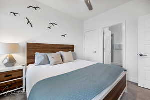 Bedroom with ceiling fan, dark carpet, and baseboards