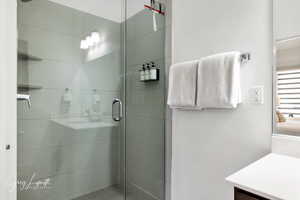 Full bath featuring a stall shower, ensuite bath, and vanity