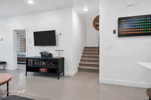 Living room featuring baseboards, stairway, and recessed lighting