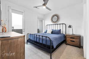 Bedroom featuring light carpet, visible vents, and a ceiling fan