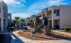 Community jungle gym with a residential view and fence